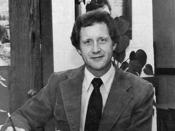 Black and white head-and-shoulders portrait of Principal David Lunter from Mount Eagle Elementary School’s 1981 to 1982 yearbook. He is seated at a table, signing paperwork.