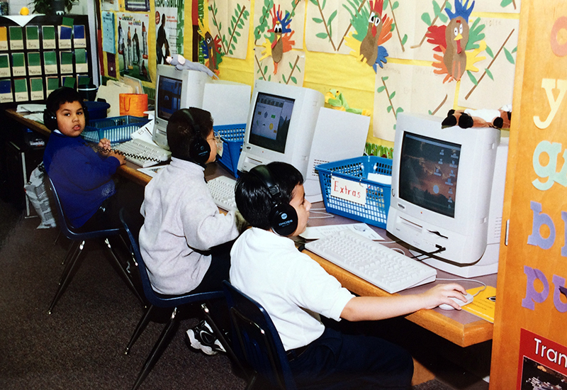 Photograph of three students working at Apple computers, taken in the late 1990s or early 2000s.